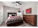 Bedroom features a dark wood dresser, a bed with a padded headboard and an abstract art piece at 7236 W Electra Ln, Peoria, AZ 85383