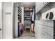 Spacious walk-in closet with gray cabinetry, ample shelving, drawers, hanging space and a small stool at 7236 W Electra Ln, Peoria, AZ 85383