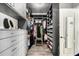A well-organized walk-in closet with gray cabinetry and shelves, featuring custom lighting and seating at 7236 W Electra Ln, Peoria, AZ 85383