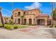 Charming two-story home with a red tile roof, stone accents, a gated entry, and lush landscaping at 7236 W Electra Ln, Peoria, AZ 85383