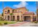 Charming two-story home with a red tile roof, stone accents, a gated entry, and lush landscaping at 7236 W Electra Ln, Peoria, AZ 85383