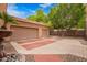 Attached three-car garage with brick accents, mature trees, and desert landscaping offering curb appeal at 7236 W Electra Ln, Peoria, AZ 85383