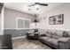 Comfortable living room with two gray couches, shuttered windows, and a ceiling fan at 7236 W Electra Ln, Peoria, AZ 85383