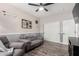 Living room featuring gray sofas, a ceiling fan, and access to another room through a door at 7236 W Electra Ln, Peoria, AZ 85383