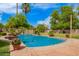 Swimming pool with an elegant water feature and beautifully maintained landscaping at 7236 W Electra Ln, Peoria, AZ 85383