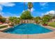 Swimming pool with a decorative waterfall feature, framed by lush landscaping at 7236 W Electra Ln, Peoria, AZ 85383