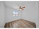 Bright bedroom featuring wood-look floors, a ceiling fan, and a window with a view of the neighborhood at 724 N Pine St, Gilbert, AZ 85233