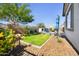 Inviting backyard showcasing a manicured lawn, rock landscaping, and a cozy outdoor seating area with a charming fireplace at 8040 E Jaeger St, Mesa, AZ 85207