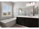Bright main bathroom features soaking tub, and modern vanity with dark cabinetry at 8040 E Jaeger St, Mesa, AZ 85207