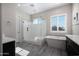 Serene main bathroom featuring a standalone tub, glass-enclosed shower, and a neutral color palette at 8040 E Jaeger St, Mesa, AZ 85207