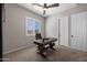 Well-lit home office features a custom desk, neutral walls, plush carpet and a ceiling fan at 8040 E Jaeger St, Mesa, AZ 85207