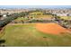 Aerial view of baseball field surrounded by trees, grassy area, and residential housing in the distance at 9230 E Scott Ave, Mesa, AZ 85212