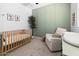 Charming Bedroom with crib, comfortable armchair, and decorative accents for a cozy space at 9230 E Scott Ave, Mesa, AZ 85212