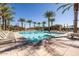 A large, community pool surrounded by palm trees and lounge chairs for residents at 9230 E Scott Ave, Mesa, AZ 85212
