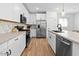 Bright kitchen features white cabinetry, stainless steel appliances, and stylish backsplash at 9230 E Scott Ave, Mesa, AZ 85212