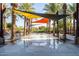 A splash pad with tables, chairs, and shaded areas surrounded by palm trees at 9230 E Scott Ave, Mesa, AZ 85212