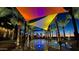 A vibrant splash pad with palm trees and shaded colorful canopies at dusk at 9230 E Scott Ave, Mesa, AZ 85212