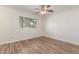 Well-lit bedroom with wood-look floors, a ceiling fan, and a window at 1047 W Laguna Dr, Tempe, AZ 85282