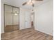 Bedroom featuring wood-look flooring, a mirrored closet, and a ceiling fan at 1047 W Laguna Dr, Tempe, AZ 85282