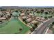 Idyllic aerial view of a community with scenic lake views, lush landscaping, and peaceful residential streets at 11101 W Wilshire Dr, Avondale, AZ 85392