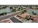 Aerial view of a home near lake showcasing curb appeal, lush landscaping, and nearby water feature at 11101 W Wilshire Dr, Avondale, AZ 85392