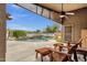 Outdoor patio featuring a pool with a rock waterfall and comfortable chairs at 11101 W Wilshire Dr, Avondale, AZ 85392