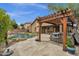 Backyard with a wooden pergola, spa, and swimming pool creates a space for relaxation at 11101 W Wilshire Dr, Avondale, AZ 85392