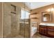 Bathroom featuring a tiled shower, vanity, shelves and mirror at 11101 W Wilshire Dr, Avondale, AZ 85392