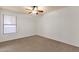 Bedroom featuring tan carpet, white walls, a ceiling fan and a window at 11101 W Wilshire Dr, Avondale, AZ 85392