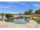 Backyard pool features stone accents, a rock waterfall, a view of the lake, and plenty of room for entertaining at 11101 W Wilshire Dr, Avondale, AZ 85392