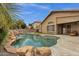 Outdoor pool area with rock waterfall, privacy fencing, and an adjacent covered patio at 11101 W Wilshire Dr, Avondale, AZ 85392