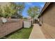 Side yard with artificial turf, a storage shed, and a secure gated entrance at 11101 W Wilshire Dr, Avondale, AZ 85392