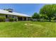 Well-maintained backyard showcasing lush lawn and mature trees with a covered patio at 12719 W Ashwood Dr, Sun City West, AZ 85375