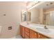Bright bathroom with double sinks, wood cabinets, and a large mirror over the vanity at 12719 W Ashwood Dr, Sun City West, AZ 85375
