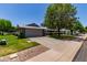 Charming single-story home featuring a spacious driveway, two-car garage, mature trees, and well-maintained lawn at 12719 W Ashwood Dr, Sun City West, AZ 85375