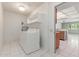 Bright laundry room with white washer and dryer, tile floor, and storage shelves at 12719 W Ashwood Dr, Sun City West, AZ 85375