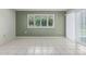 Bright living room featuring neutral tile flooring, shuttered window, and sliding glass doors with vertical blinds at 12719 W Ashwood Dr, Sun City West, AZ 85375