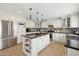 Beautiful white kitchen featuring an island, granite countertops, stainless steel appliances, and modern lighting at 1285 E Horseshoe Ave, Gilbert, AZ 85296
