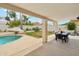 Spacious covered patio featuring a dining table, in-ground pool and lush tropical landscaping at 1285 E Horseshoe Ave, Gilbert, AZ 85296