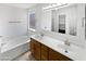 Bright bathroom features double sinks, a soaking tub, and a large mirror at 15162 W Monroe St, Goodyear, AZ 85338