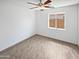 Vacant bedroom with tile floors, a ceiling fan, and a window that lets in natural light at 15162 W Monroe St, Goodyear, AZ 85338