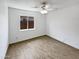 Neutral bedroom with a white ceiling fan and a window view of the fenced backyard at 15162 W Monroe St, Goodyear, AZ 85338