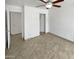 Neutral bedroom featuring tile flooring, a ceiling fan, closet, and a door to another room at 15162 W Monroe St, Goodyear, AZ 85338