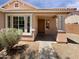 Inviting front porch with decorative pillars and a manicured shrub at 15162 W Monroe St, Goodyear, AZ 85338