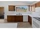 Bright kitchen featuring wood cabinets, white countertops, and a view of the backyard through a window above the sink at 15162 W Monroe St, Goodyear, AZ 85338