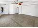 Large, tile-floored living room with fan and well-lit entryway at 15162 W Monroe St, Goodyear, AZ 85338