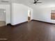 Open living room with dark wood-look tile flooring, neutral walls, and a ceiling fan at 15162 W Monroe St, Goodyear, AZ 85338