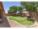 Well-maintained backyard with lush green grass, mature trees, and privacy fence, perfect for outdoor activities at 15674 W Mackenzie Dr, Goodyear, AZ 85395