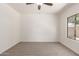 Empty bedroom with carpet flooring, a ceiling fan, and a window providing natural light at 15674 W Mackenzie Dr, Goodyear, AZ 85395