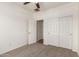 Carpeted bedroom featuring a ceiling fan and a closet with sliding doors for storage at 15674 W Mackenzie Dr, Goodyear, AZ 85395